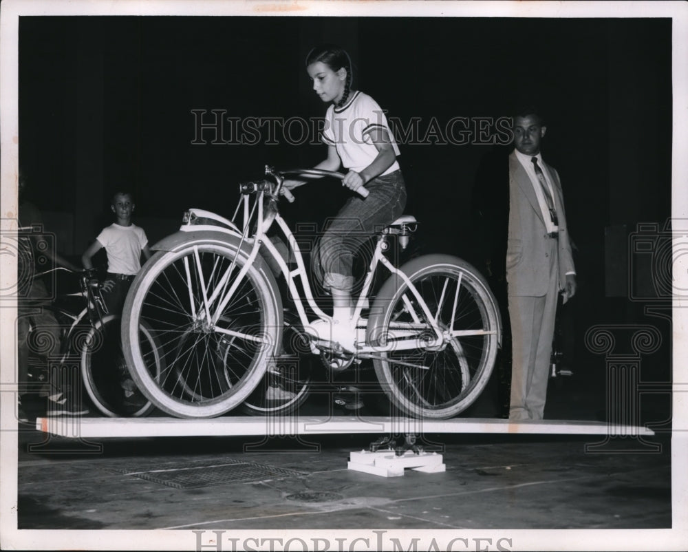1955 Press Photo Jacqueline Kaeperski crossing obstacle course on her bicycle
