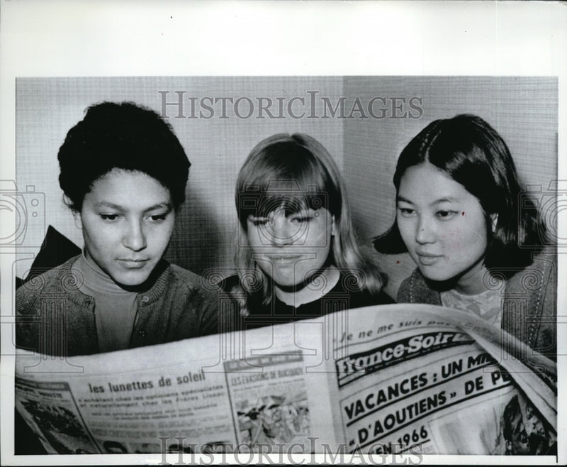 Load image into Gallery viewer, 1967 Press Photo R. Alexander, K. Winn &amp; C. Watanbe read french newspaper
