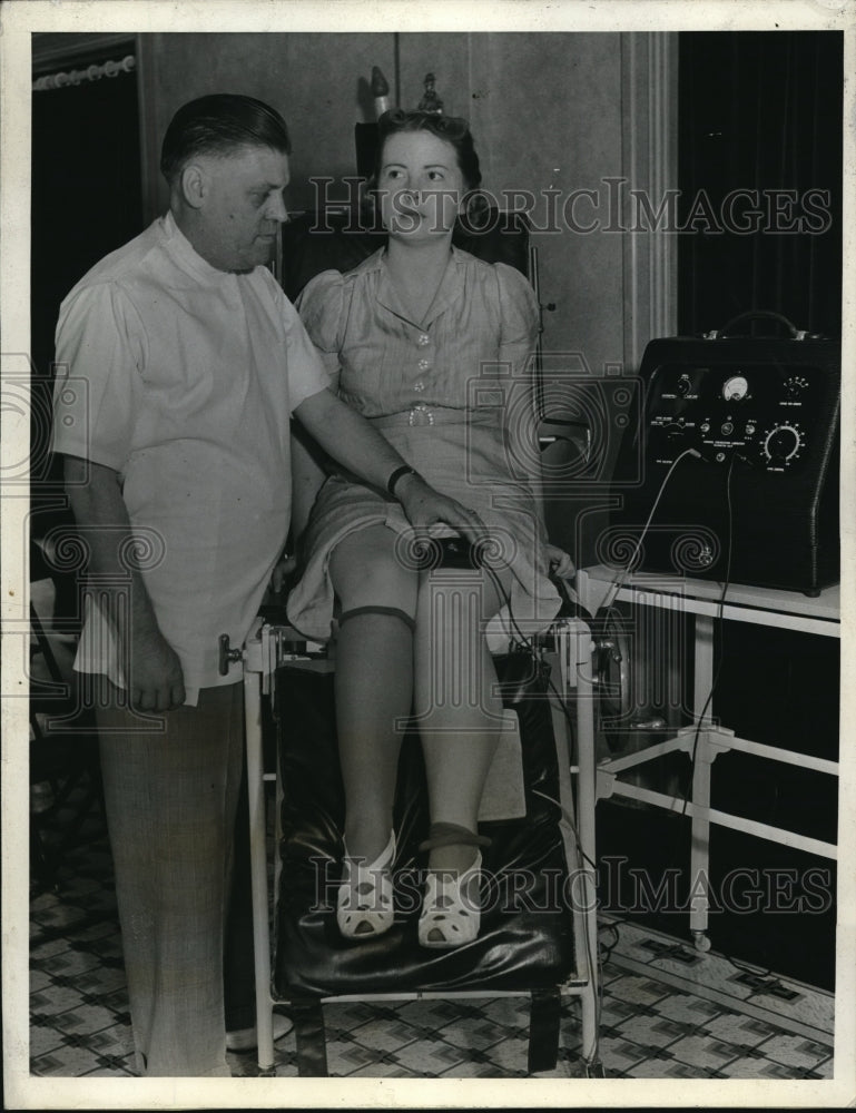 Load image into Gallery viewer, 1938 Press Photo Dr. Charles Henry Wood treating paralysis on Miss Carol Thomas
