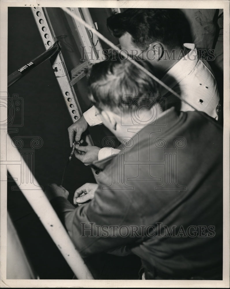 1945 Press Photo Here crewmen are making fast the cable to the aft section of