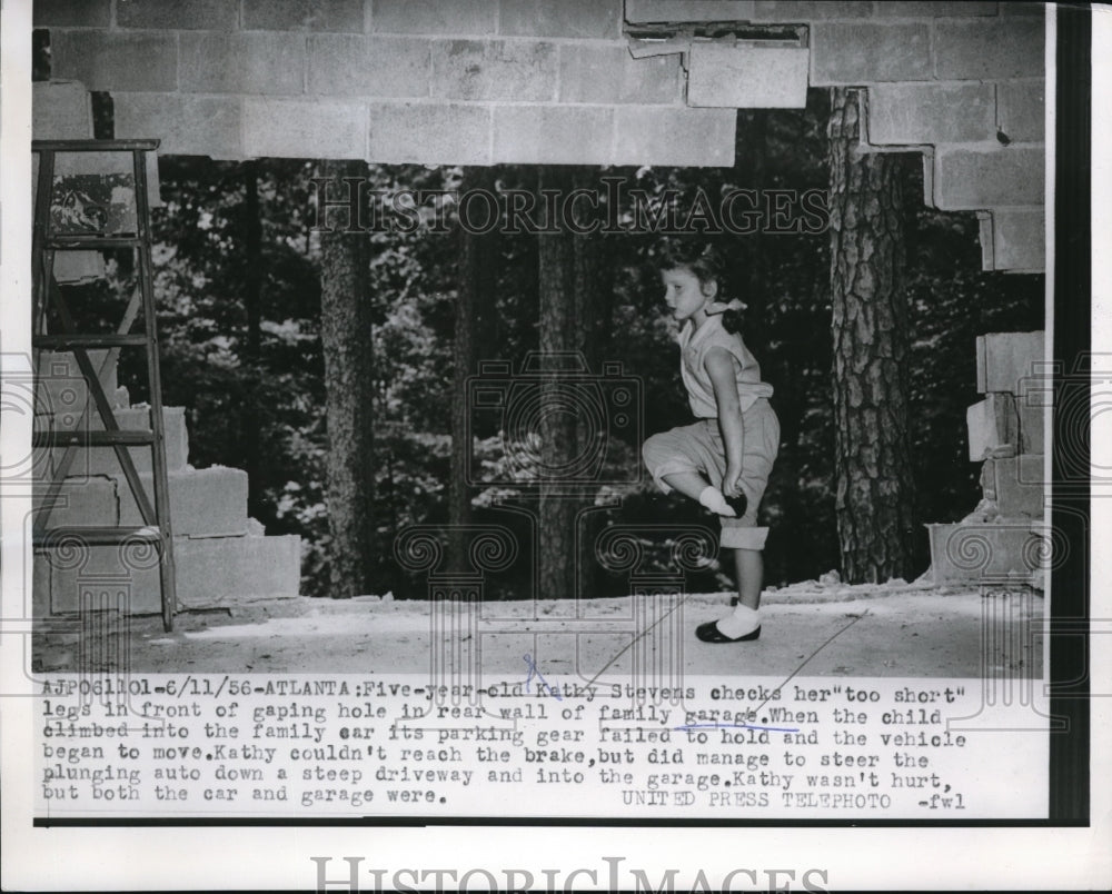 1956 Press Photo Kathy Stevens checks her legs in front of gaping hole