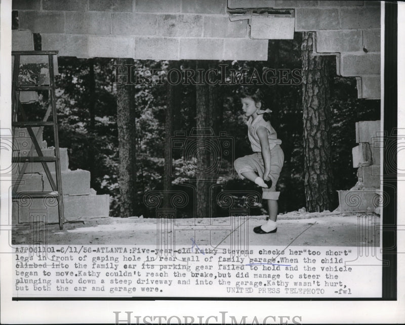 Load image into Gallery viewer, 1956 Press Photo Kathy Stevens checks her legs in front of gaping hole
