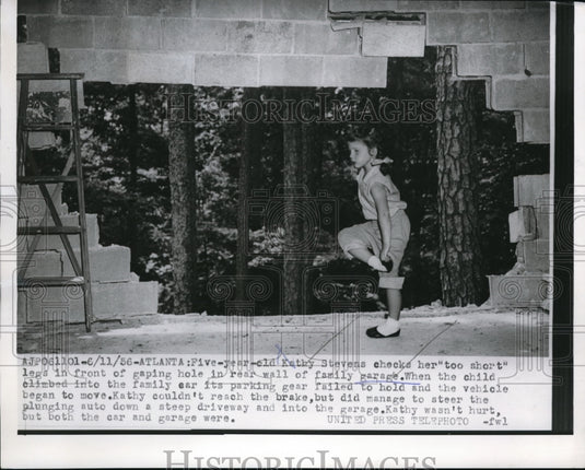 1956 Press Photo Kathy Stevens checks her legs in front of gaping hole