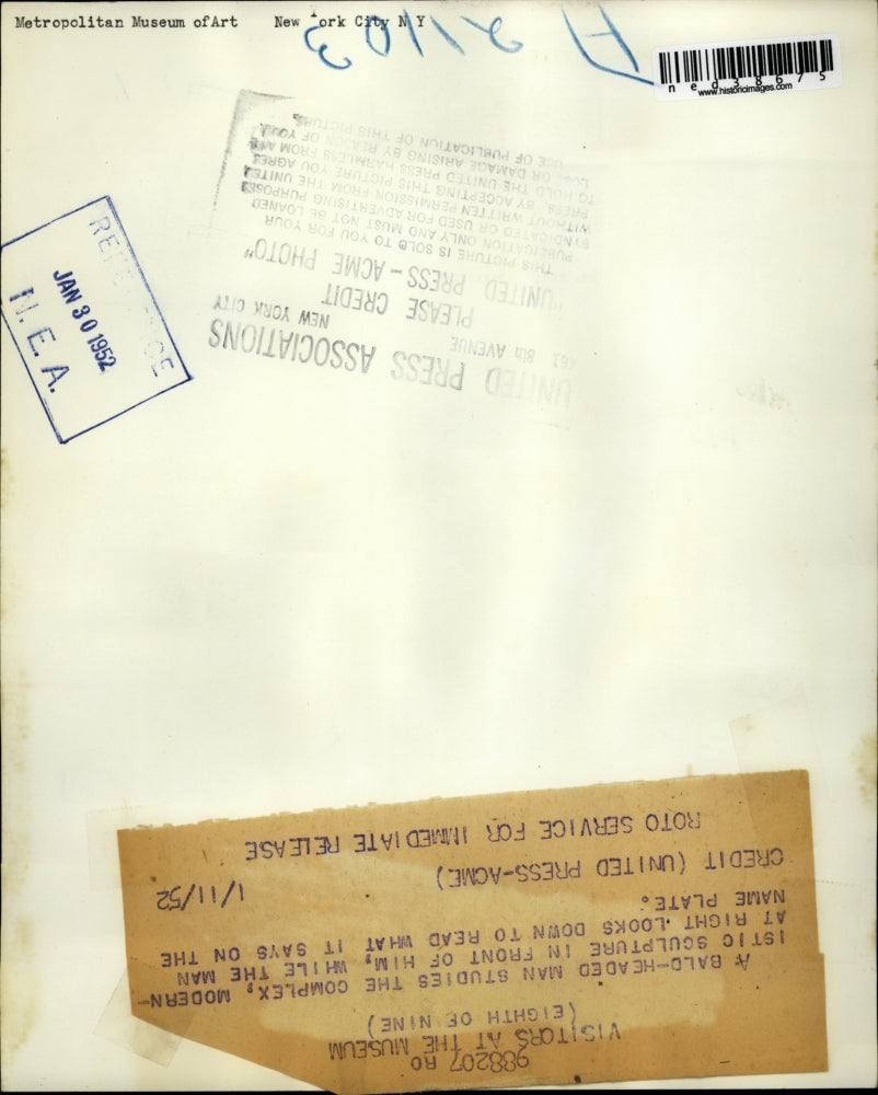 1952 Press Photo A baldheaded man studies complex modernistic sculpture while