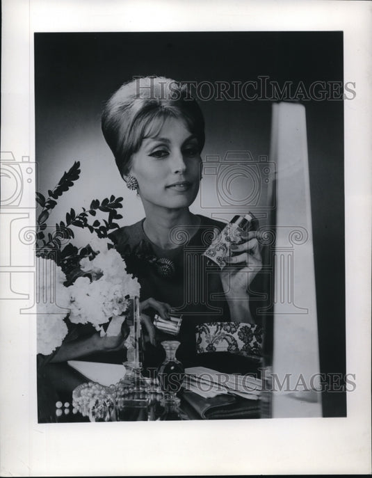 1962 Press Photo Model holding a bottle of cologne