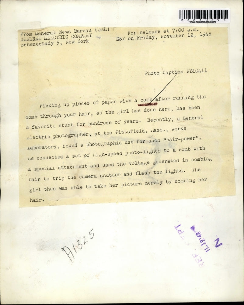 1948 Press Photo Comb picking up a piece of paper