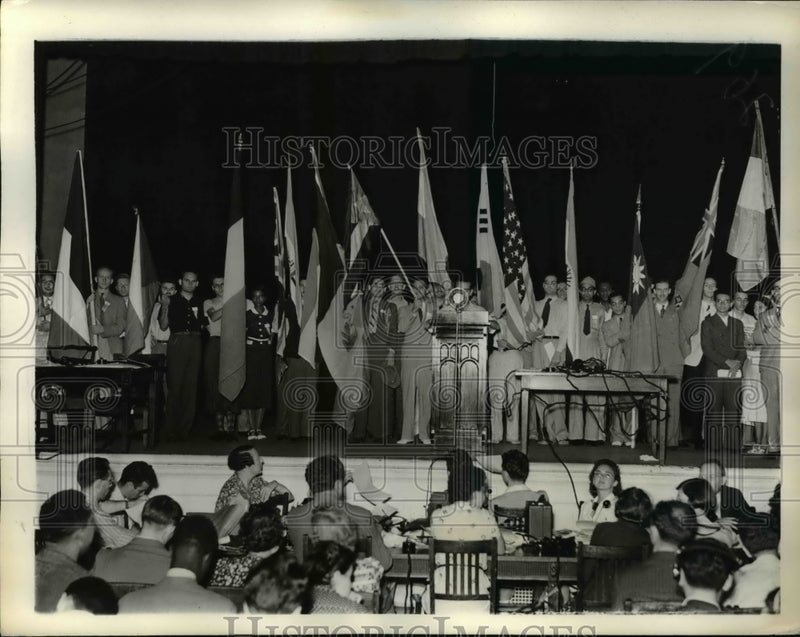 Load image into Gallery viewer, 1938 Press Photo Delegates on platform holding flags as Youth Congress closes
