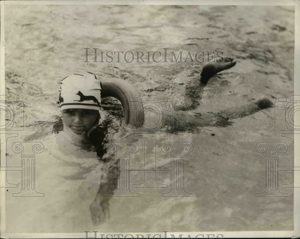 1932 Press Photo Gloria Haddad in a inflated spare tire while in swimming