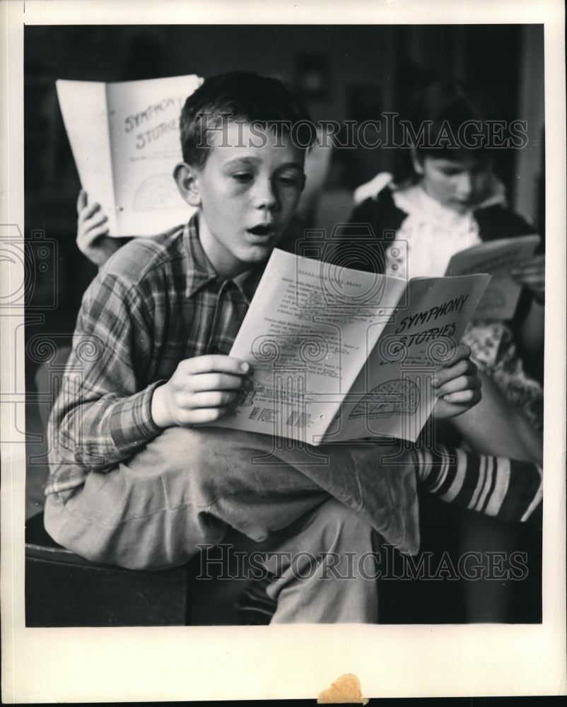 1948 Press Photo Teddy Moore Reads Booklets On Composers