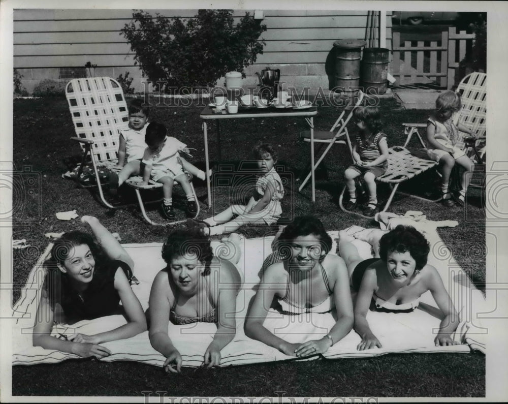 1960 Press Photo Sunbathing Women and playing children