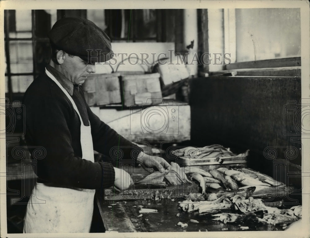 1936 Press Photo Man Cleaning Fish