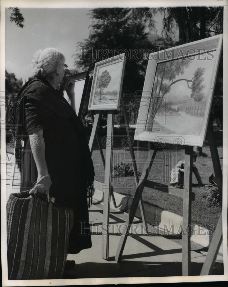 1957 Press Photo An elderly woman pauses from her shopping