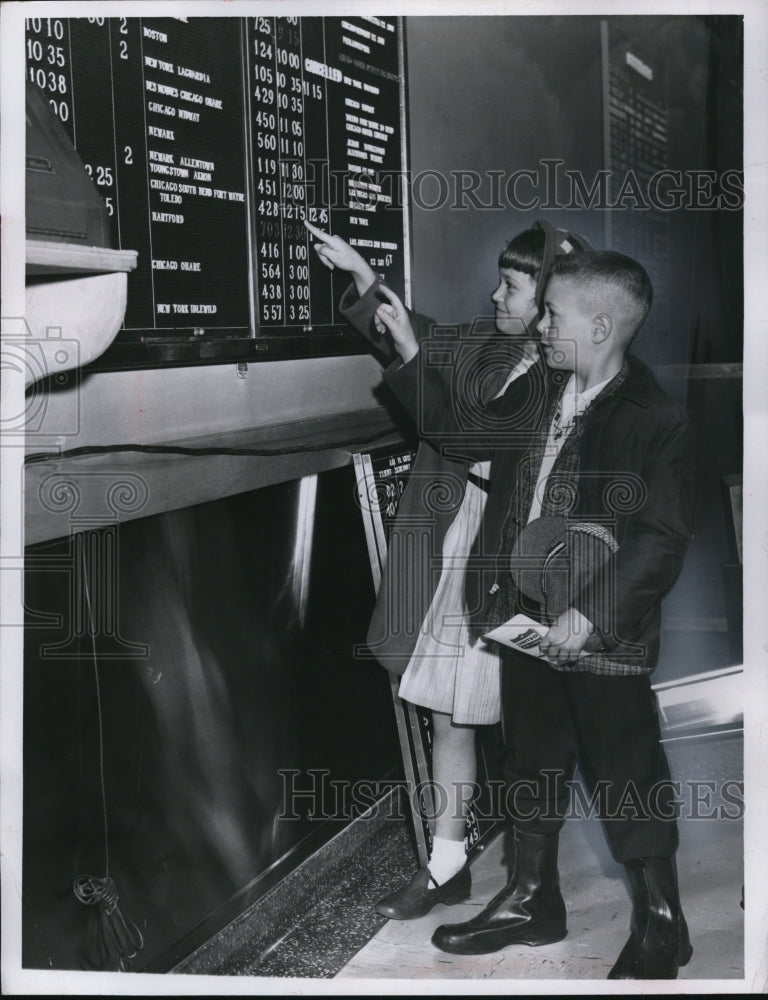 Load image into Gallery viewer, 1961 Press Photo Barbra Sheriff and Todd Vetrosky check flight times.
