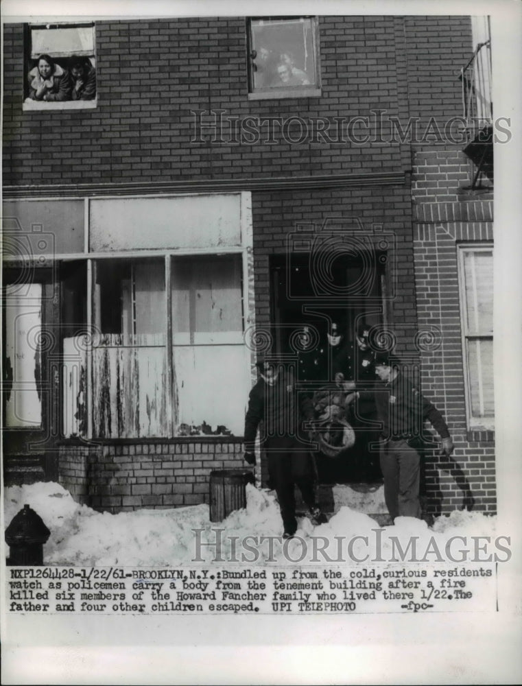 1961 Press Photo Bundled up from cold, curious residents watch as policemen- Historic Images