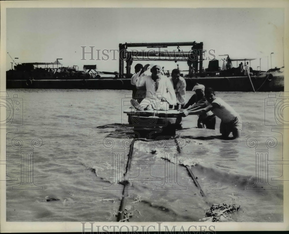 1963 Press Photo Egyptian workers on pulley truck to village elder in Nile River