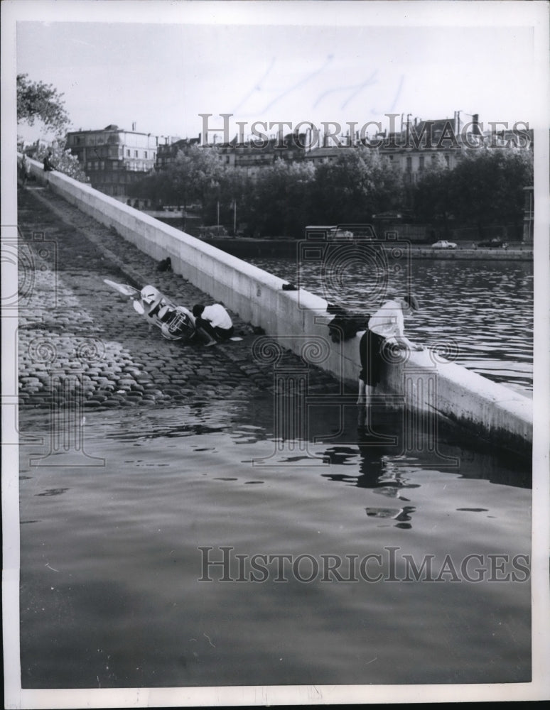 1957 Press Photo Man Cleaning Clothes on Seine River in Paris