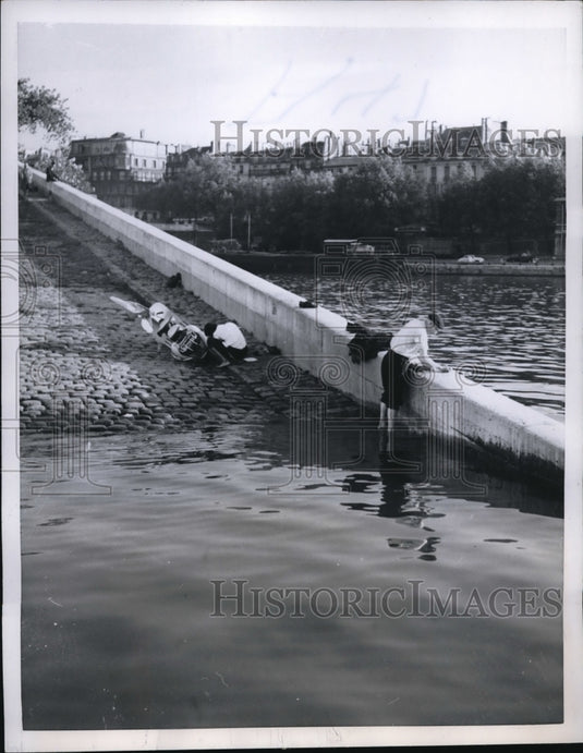 1957 Press Photo Man Cleaning Clothes on Seine River in Paris