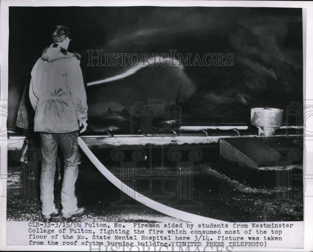 1956 Press Photo Fireman aided by student fighting fire MO State Mental Hospital
