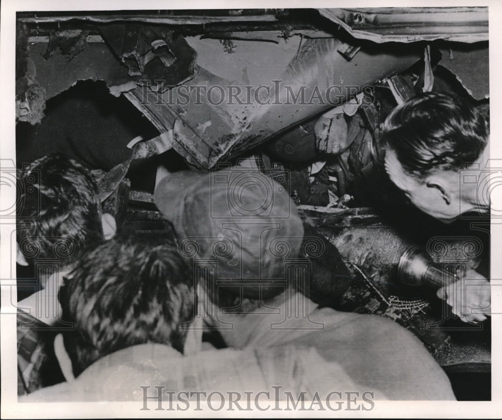1951 Press Photo Rescue crew peers through a gaping hole of a wrecked car