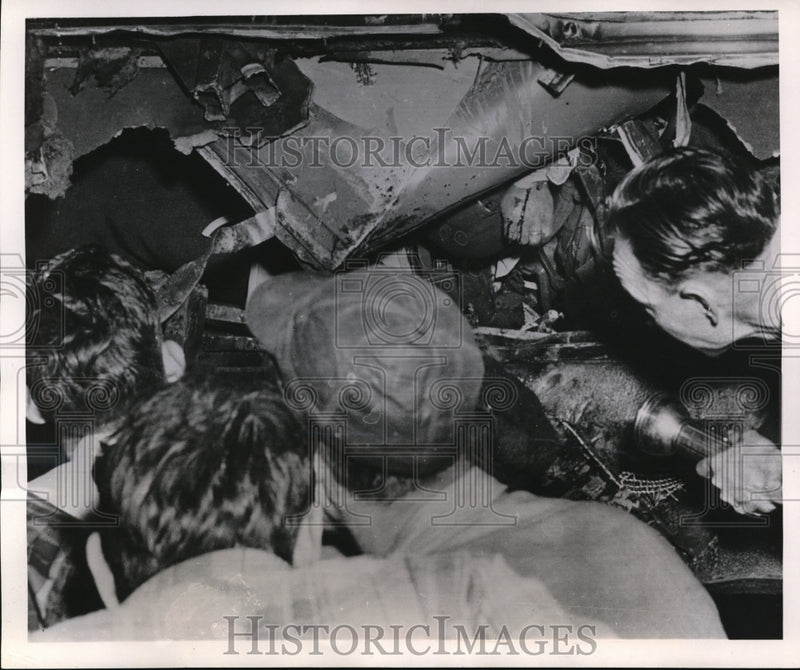 Load image into Gallery viewer, 1951 Press Photo Rescue crew peers through a gaping hole of a wrecked car
