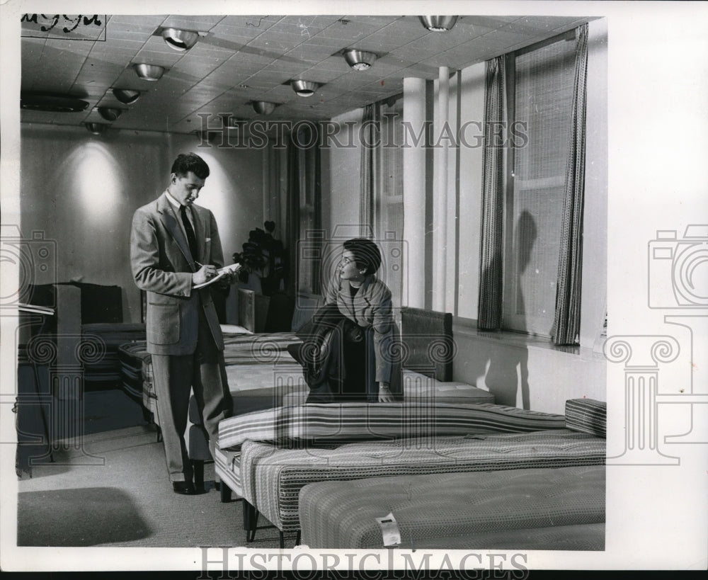 1954 Press Photo Homemaker shopping winter bedding sales makes sure she