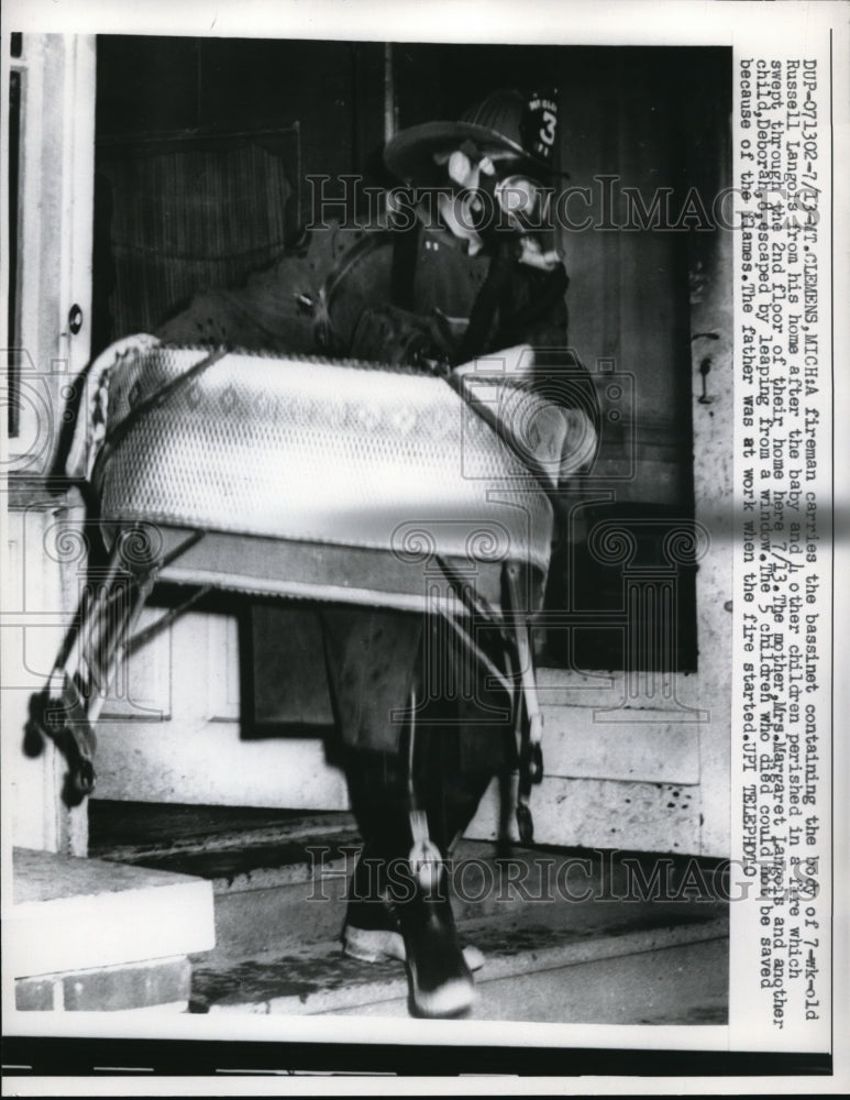 1959 Press Photo Fireman as he Carries the Bassinet