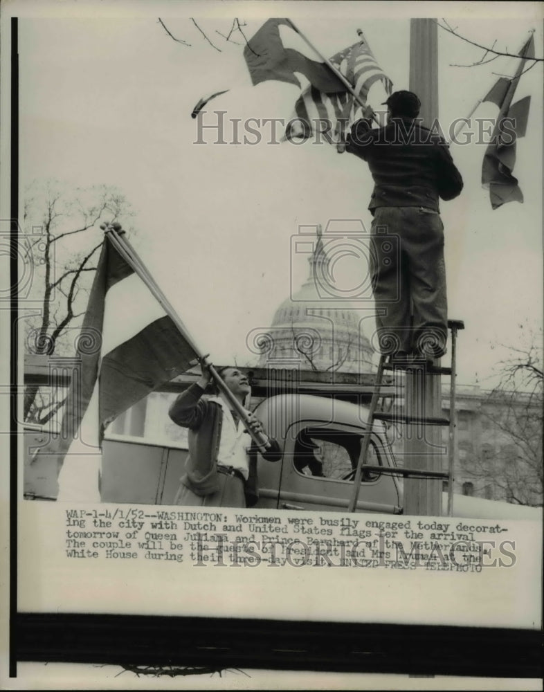 1952 Press Photo Workmen decorate city with Dutch & US flags for Queen Juliana