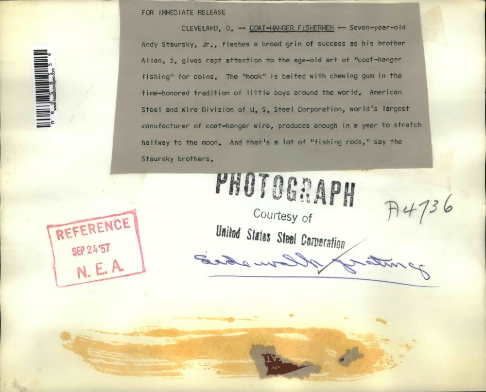 1957 Press Photo Cleveland Ohio Andy & Allen Staursky Jr get coins from grates