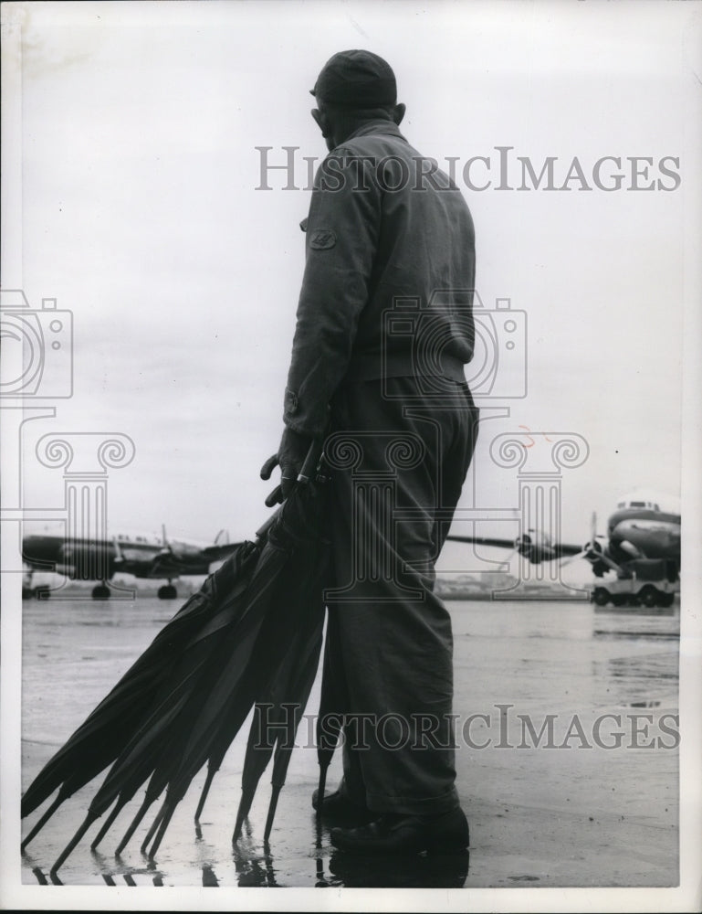 Load image into Gallery viewer, 1957 Press Photo Rome Italy Ciamping Airport &amp; worker with umbrellas
