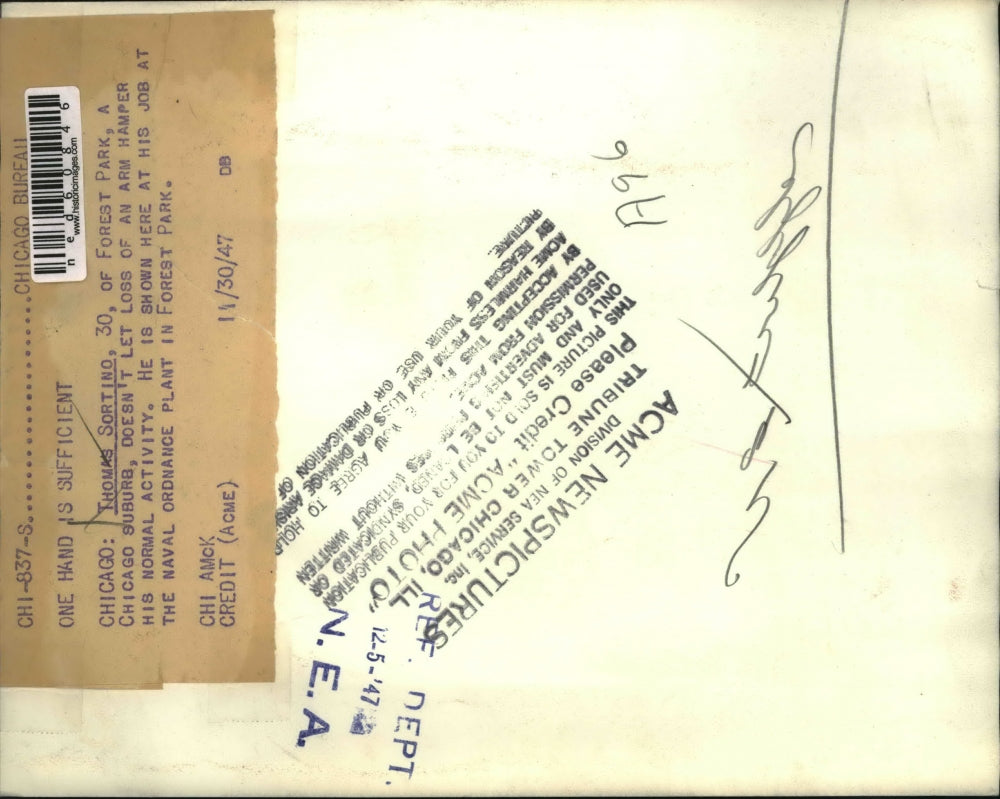 1947 Press Photo Thomas Sortino doing his job despite of a loss arm