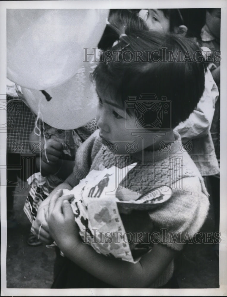 1959 Press Photo Tokyo youngster watches sadly as her old doll goes in flame