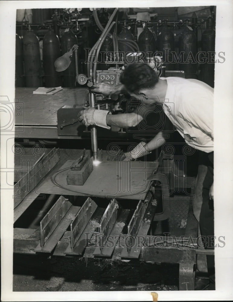 1941 Press Photo Workman cuts armor plate at plant of Breeze Corporations Inc