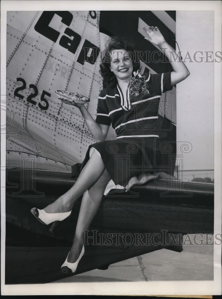 1949 Press Photo Ann Marie Maurer holds cherry pie while sitting on plane- Historic Images