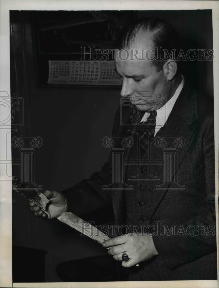 1944 Press Photo Detective David Ennis examines the evidence stick