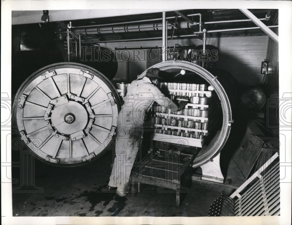 1941 Press Photo Cans of Ripe Olive entering a pressure cooker for sterilization