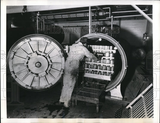 1941 Press Photo Cans of Ripe Olive entering a pressure cooker for sterilization