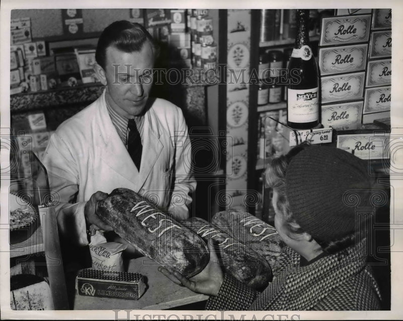Load image into Gallery viewer, 1951 Press Photo German housewife purchases a loaf of bread marked as West

