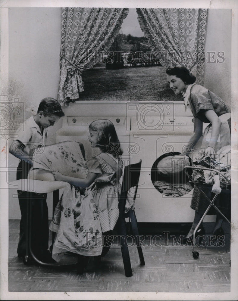 Load image into Gallery viewer, 1953 Press Photo modern appliances like the ironer are safe for children.
