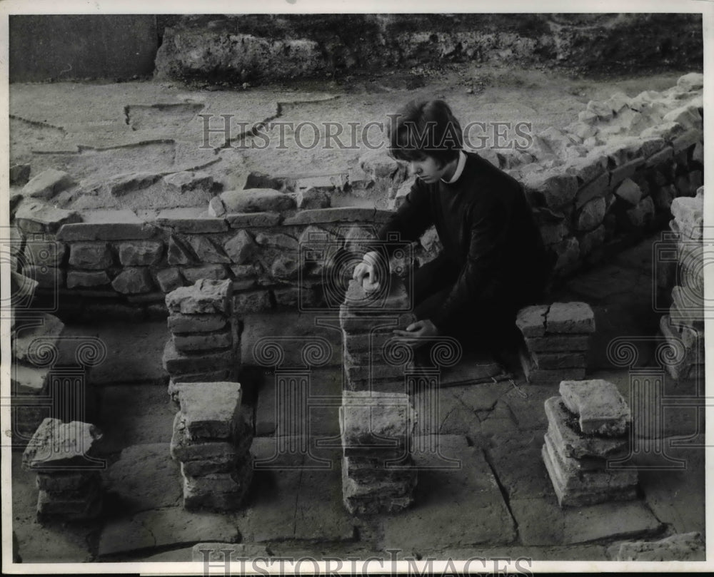 1968 Press Photo Girl brushes the hypocaust, which used for underfloor heating- Historic Images