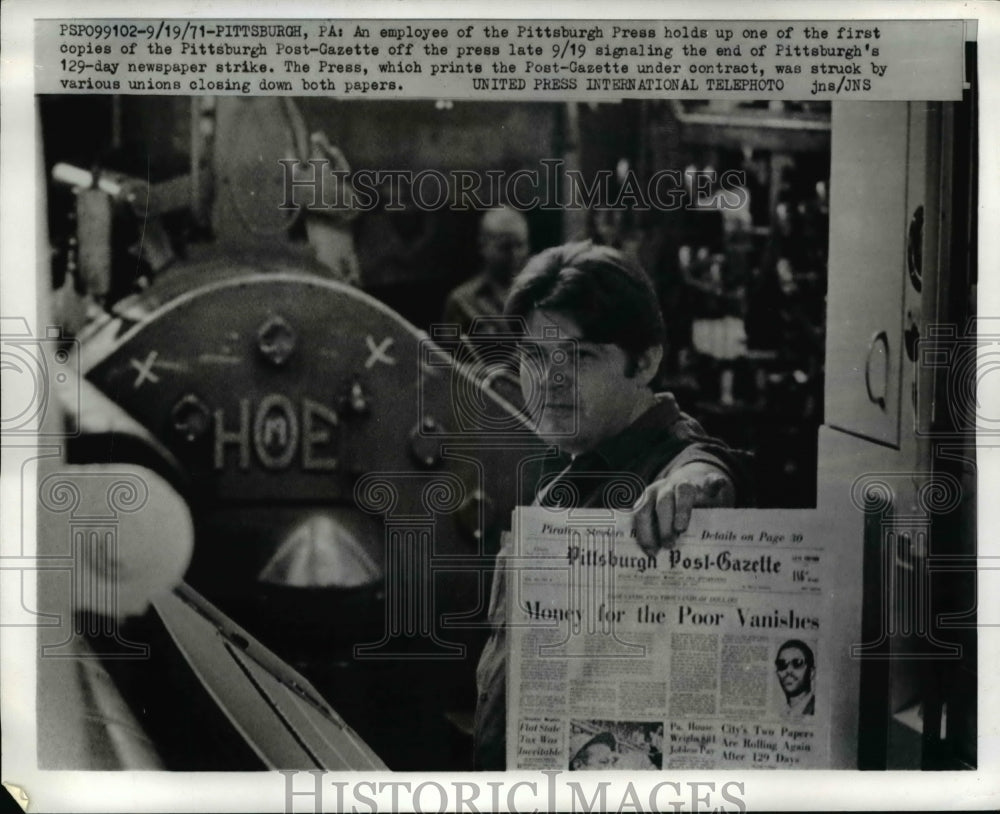 1971 Press Photo An employee of the Pittsburgh Press holds up a news paper