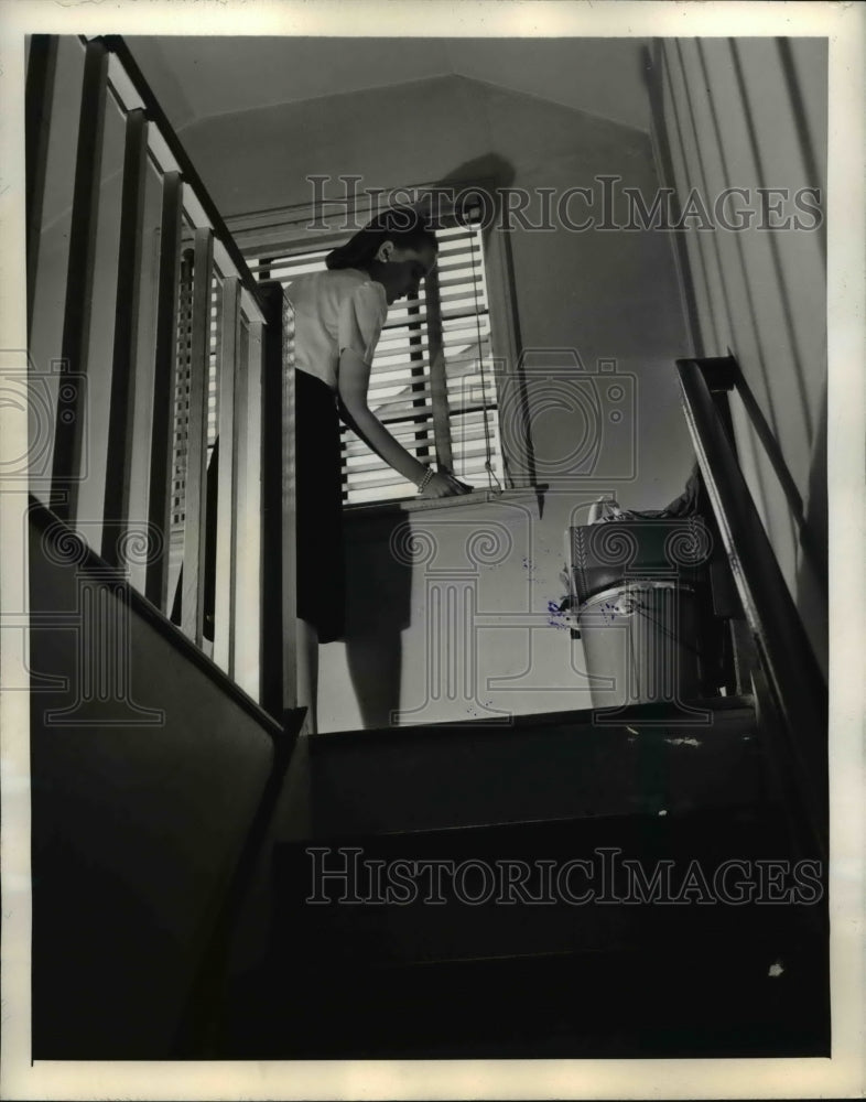 1945 Press Photo Woman Opening Attic Windows for Ventilation