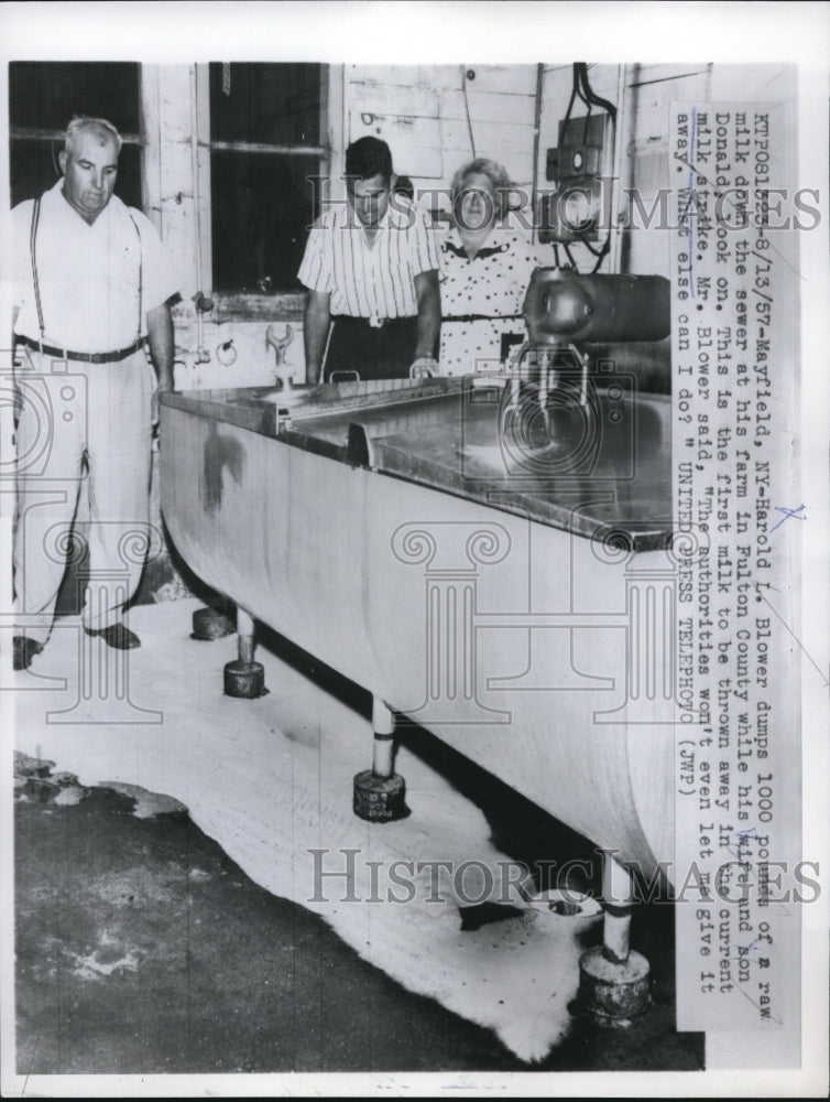 Load image into Gallery viewer, 1957 Press Photo Harold L. Blower dumps 1000 pounds of a raw milk down the sewer
