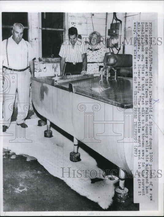 1957 Press Photo Harold L. Blower dumps 1000 pounds of a raw milk down the sewer