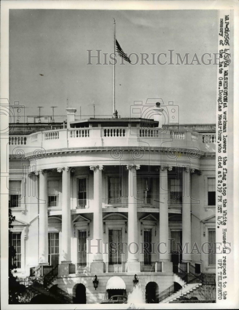1964 Press Photo Washington Dc a workman lowers the flag atop the White House
