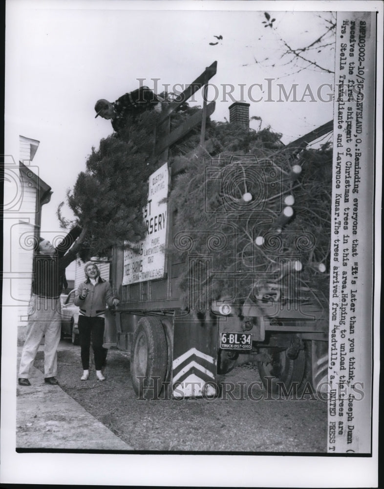 Load image into Gallery viewer, 1957 Press Photo of Joseph Dunn and Lawrence Kunar unloading Christmas trees.
