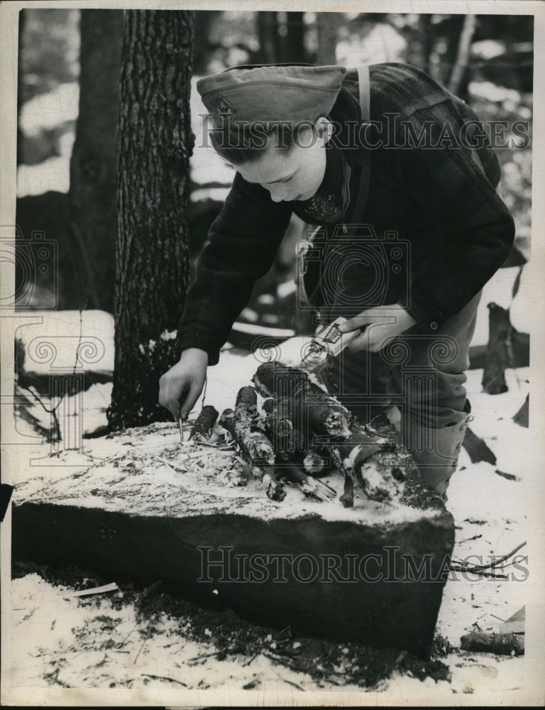 1959 Press Photo of James Carleton building a fire on a rock.