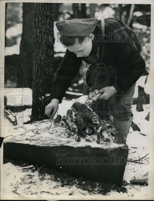 1959 Press Photo of James Carleton building a fire on a rock.