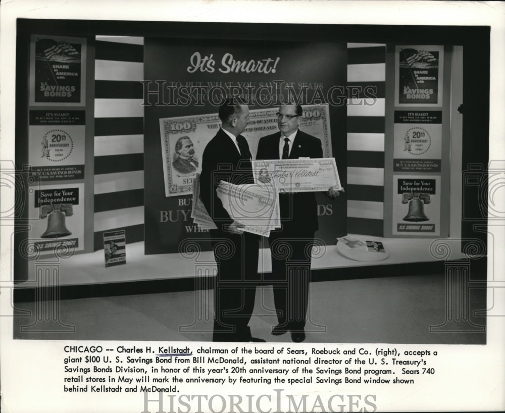1961 Press Photo Charles H. Kellstadt (R) accepts a $100 saving bond from BIll
