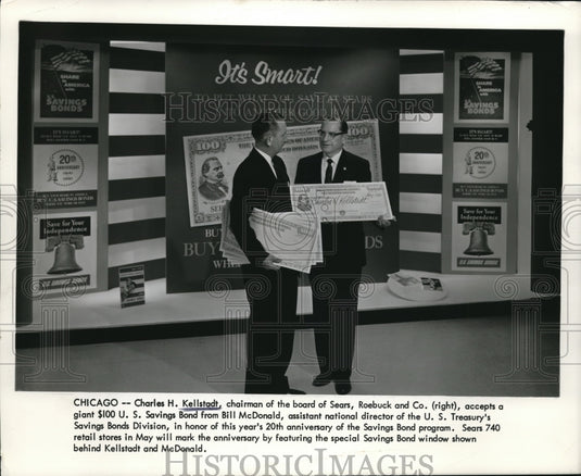 1961 Press Photo Charles H. Kellstadt (R) accepts a $100 saving bond from BIll