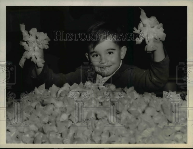 Load image into Gallery viewer, 1943 Press Photo Samuel D. McKinstry III is buried in candy.

